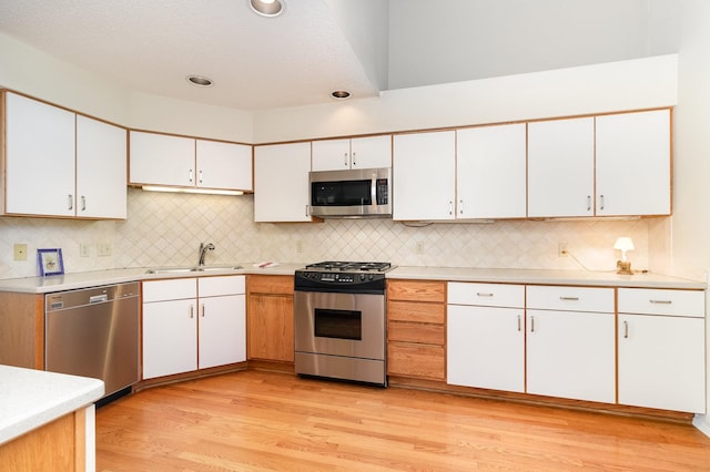 kitchen featuring white cabinets, light countertops, a sink, and appliances with stainless steel finishes