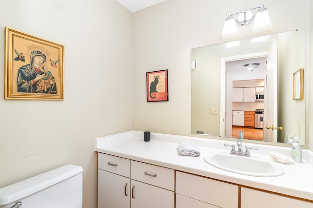bathroom with tasteful backsplash, vanity, and toilet