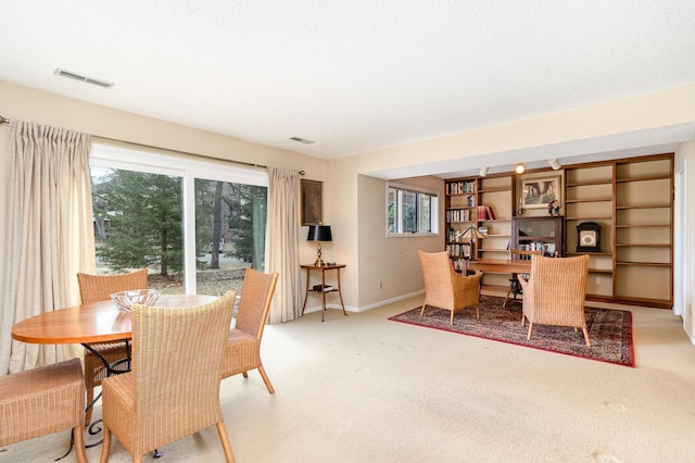 carpeted dining area featuring baseboards and visible vents