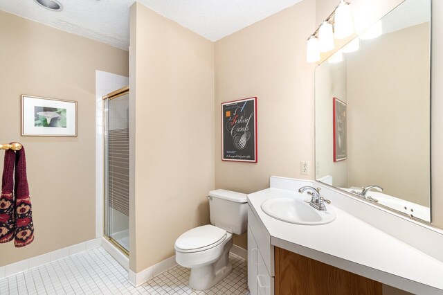 bathroom featuring tile patterned floors, toilet, a shower stall, and vanity