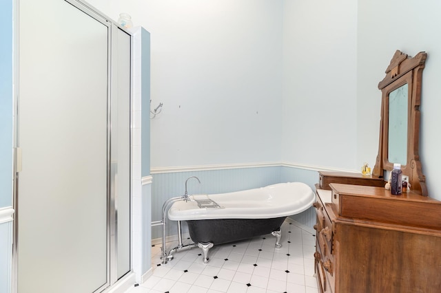 full bath featuring a freestanding tub, a wainscoted wall, and a stall shower