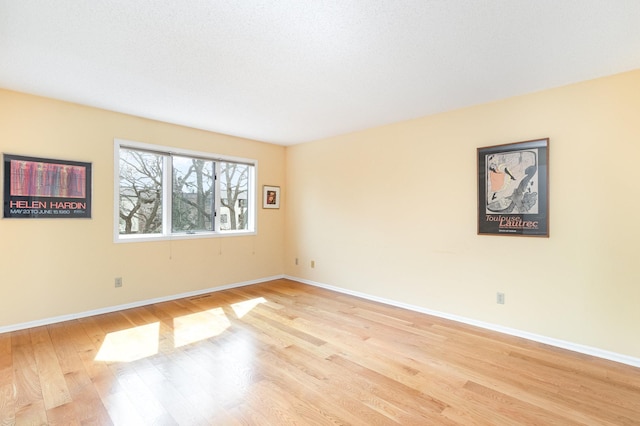 empty room featuring light wood-style flooring and baseboards