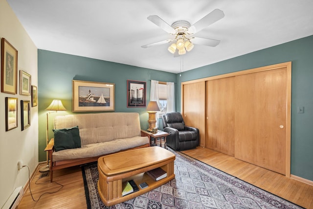 W3527 2nd St, Maiden Rock, WI 54750 - living area with a baseboard heating unit, wood finished floors, a ceiling fan, and baseboards