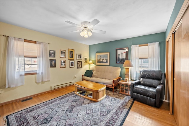 W3527 2nd St, Maiden Rock, WI 54750 - living area featuring baseboard heating, a ceiling fan, wood finished floors, and baseboards