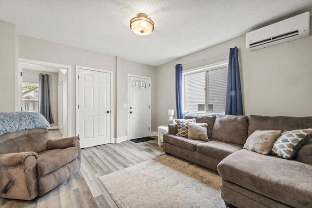 588 Van Buren Ave, Saint Paul, MN 55103 - living room with an AC wall unit, wood finished floors, a textured ceiling, and baseboards