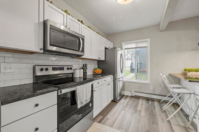 588 Van Buren Ave, Saint Paul, MN 55103 - kitchen with appliances with stainless steel finishes, baseboard heating, tasteful backsplash, light wood-style flooring, and a textured ceiling