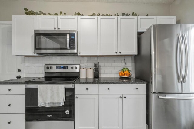 588 Van Buren Ave, Saint Paul, MN 55103 - kitchen with appliances with stainless steel finishes, white cabinetry, backsplash, and dark stone countertops