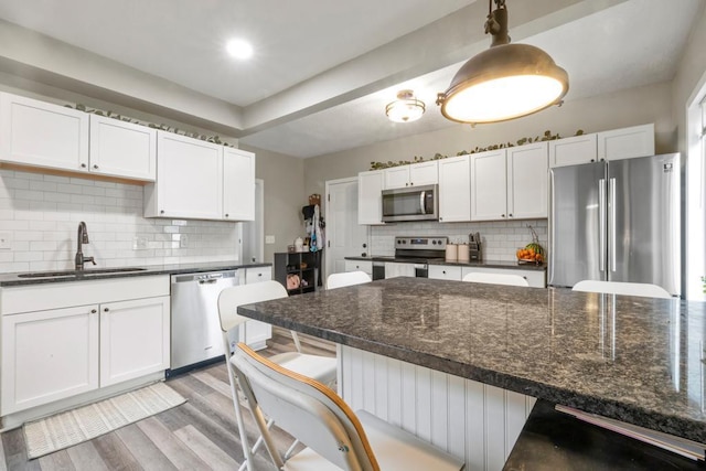 588 Van Buren Ave, Saint Paul, MN 55103 - kitchen with appliances with stainless steel finishes, a sink, backsplash, and white cabinetry