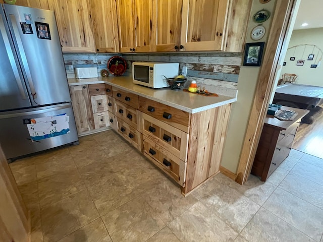 18063 Bernard Trl, Brainerd, MN 56401 - kitchen featuring freestanding refrigerator, white microwave, light countertops, and tasteful backsplash