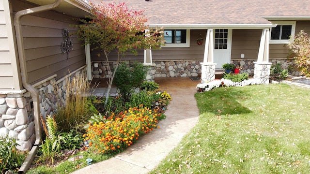 18063 Bernard Trl, Brainerd, MN 56401 - doorway to property with stone siding, covered porch, a shingled roof, and a lawn
