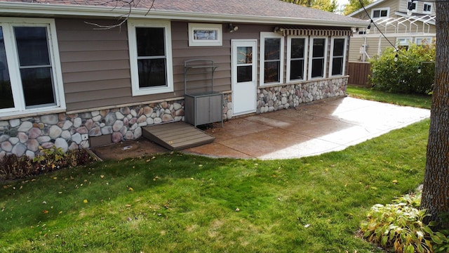 18063 Bernard Trl, Brainerd, MN 56401 - back of property with stone siding, a patio, and a shingled roof