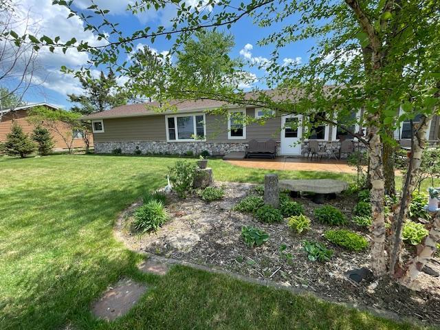 18063 Bernard Trl, Brainerd, MN 56401 - view of front of property with a patio area, a front yard, and stone siding
