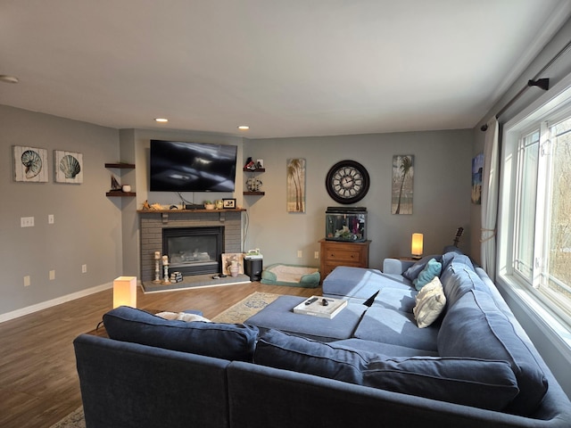 living room with recessed lighting, baseboards, a brick fireplace, and wood finished floors