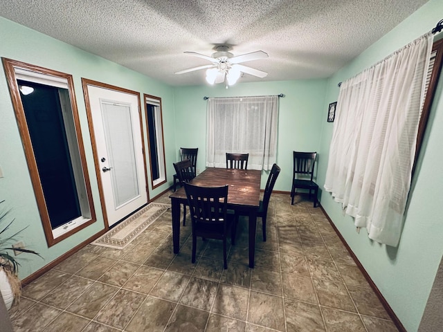 dining room featuring baseboards, a textured ceiling, and a ceiling fan