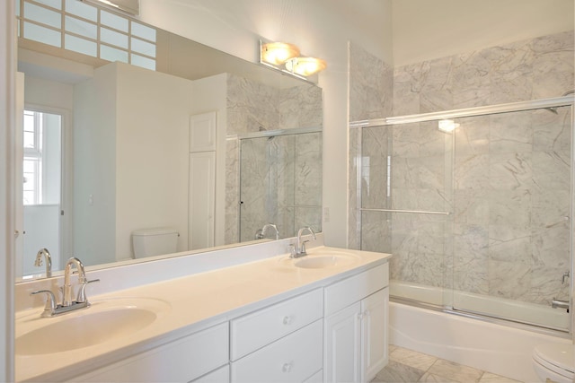 full bathroom featuring enclosed tub / shower combo, marble finish floor, toilet, and a sink