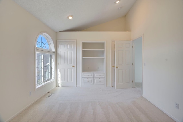 unfurnished bedroom with carpet, visible vents, lofted ceiling, recessed lighting, and a textured ceiling