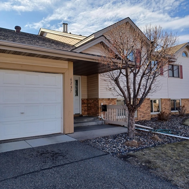 6237 Magda Dr Unit A, Maple Grove, MN 55369 - view of front of property with covered porch, a garage, and brick siding