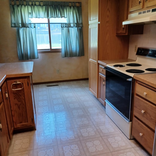 6237 Magda Dr Unit A, Maple Grove, MN 55369 - kitchen with electric stove, under cabinet range hood, light countertops, brown cabinetry, and baseboards