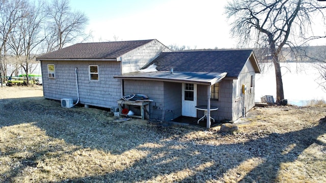 back of house with a shingled roof
