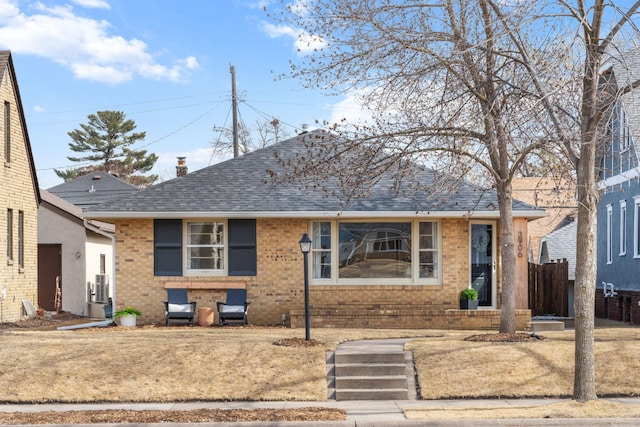 view of front facade with brick siding and roof with shingles