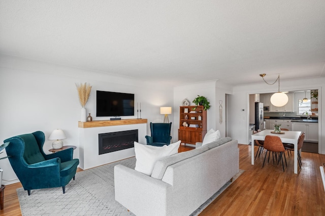 living area with light wood-style flooring, a fireplace, and a textured ceiling