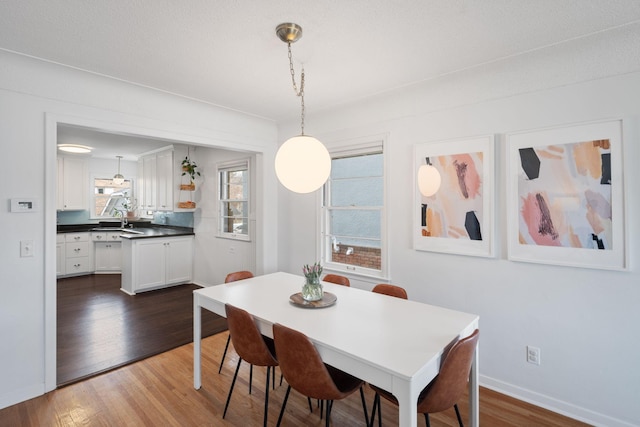 dining space with baseboards and wood finished floors