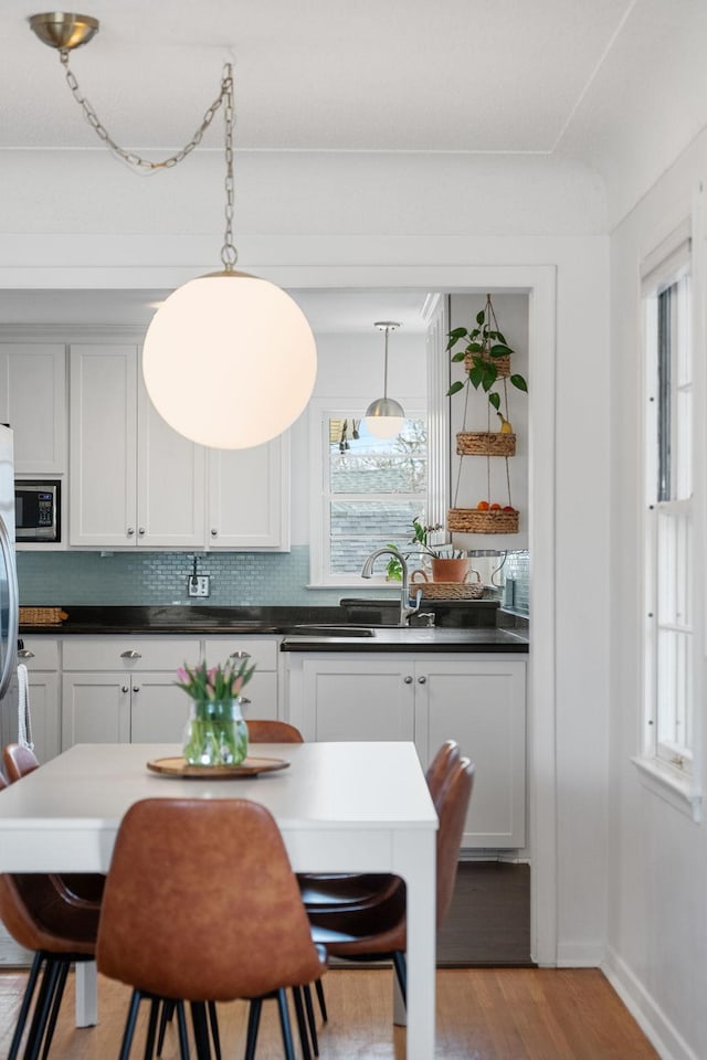 dining space featuring baseboards and light wood-style floors