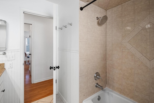 full bathroom with wainscoting, tub / shower combination, vanity, and wood finished floors