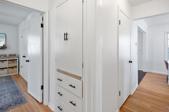 hallway featuring baseboards and light wood-style flooring