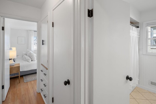 bathroom with connected bathroom, a shower with curtain, visible vents, and wood finished floors