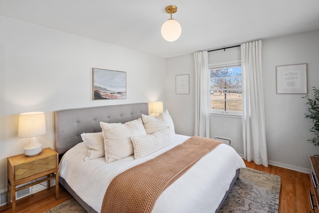 bedroom with baseboards and wood finished floors