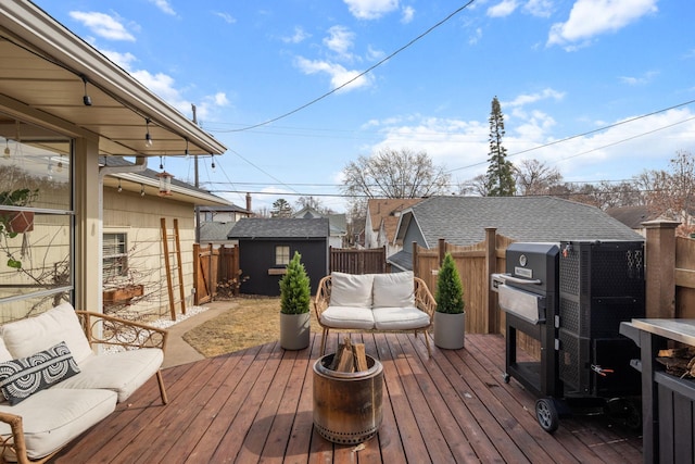 deck featuring an outdoor structure, fence, an outdoor living space, and a shed