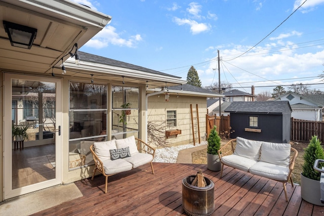 deck featuring an outbuilding, a storage unit, and fence