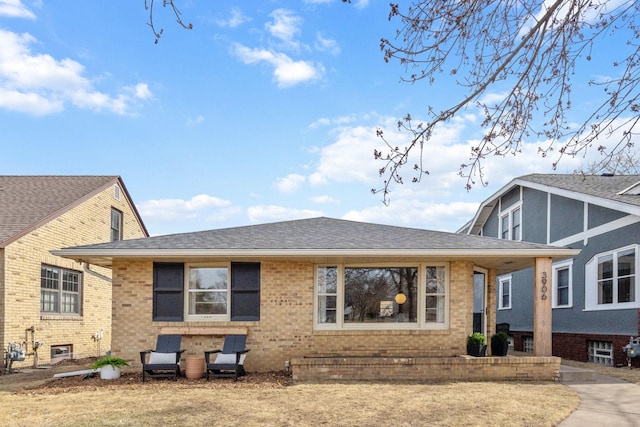 exterior space with brick siding and a shingled roof