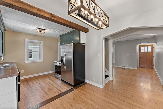 910 Nevada Ave W, Saint Paul, MN 55117 - kitchen featuring appliances with stainless steel finishes, arched walkways, light wood finished floors, and baseboards