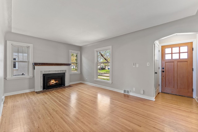 910 Nevada Ave W, Saint Paul, MN 55117 - unfurnished living room with light wood-style flooring, baseboards, and a brick fireplace