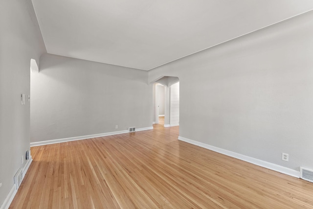 910 Nevada Ave W, Saint Paul, MN 55117 - spare room featuring arched walkways, light wood-style floors, and baseboards