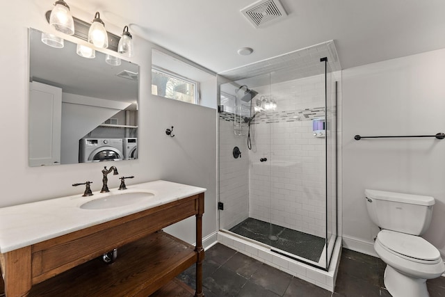 910 Nevada Ave W, Saint Paul, MN 55117 - full bathroom with washing machine and dryer, toilet, a shower stall, vanity, and baseboards