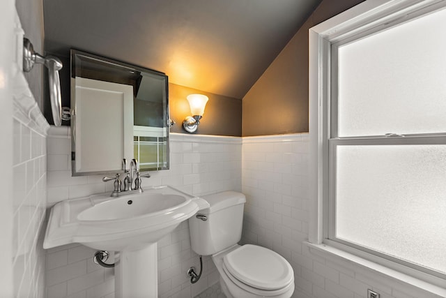 910 Nevada Ave W, Saint Paul, MN 55117 - half bathroom featuring tile walls, toilet, lofted ceiling, and wainscoting
