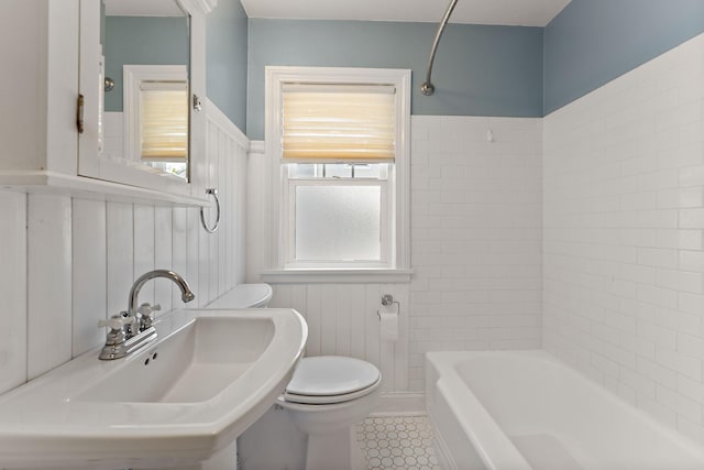 910 Nevada Ave W, Saint Paul, MN 55117 - bathroom with a sink, toilet, tile patterned flooring, wainscoting, and shower / bath combination