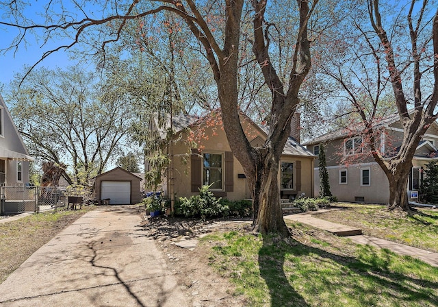 910 Nevada Ave W, Saint Paul, MN 55117 - view of front of property featuring a garage, driveway, an outdoor structure, fence, and stucco siding