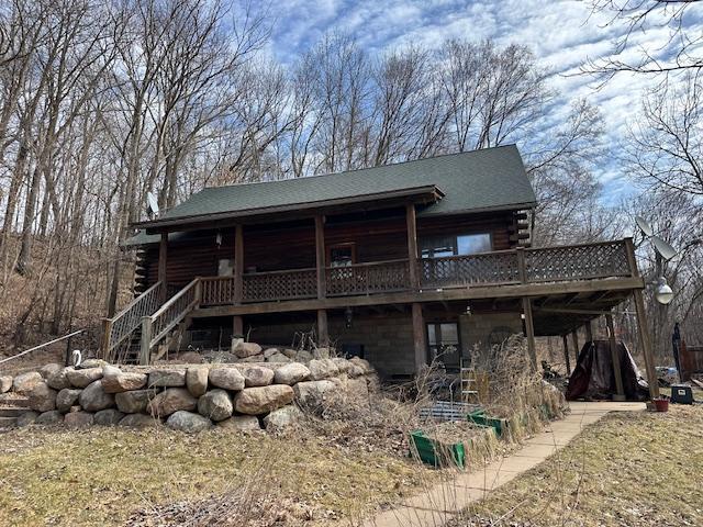 rear view of house with log siding, a shingled roof, stairs, and a deck