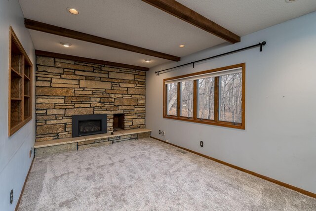 19 Robin Ct, North Mankato, MN 56003 - unfurnished living room featuring carpet, beamed ceiling, a stone fireplace, baseboards, and a textured ceiling