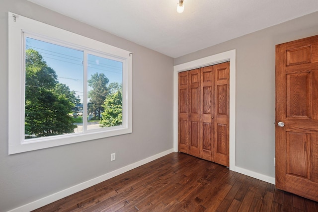 5446 Bartlett Blvd, Mound, MN 55364 - unfurnished bedroom with multiple windows, dark wood-style flooring, and a closet