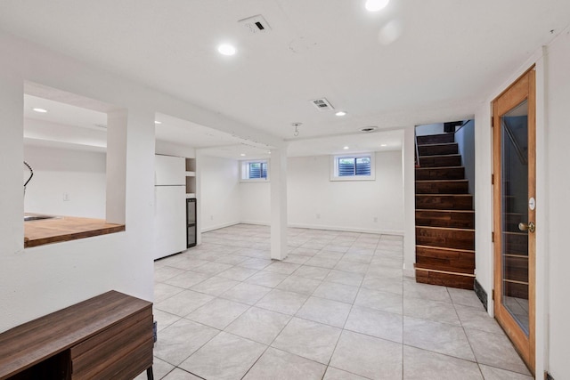 5446 Bartlett Blvd, Mound, MN 55364 - basement with freestanding refrigerator, stairs, recessed lighting, and light tile patterned flooring
