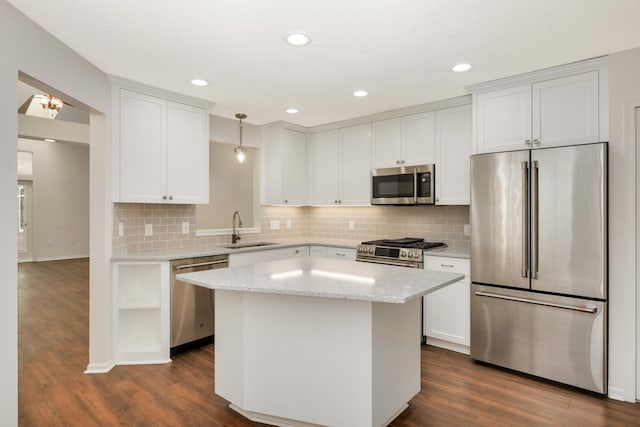 kitchen featuring appliances with stainless steel finishes, a sink, dark wood finished floors, a kitchen island, and recessed lighting