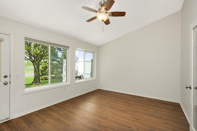 spare room featuring dark wood finished floors, lofted ceiling, baseboards, and a ceiling fan