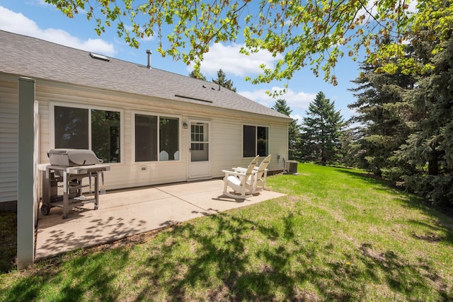 rear view of house featuring a lawn, a patio area, roof with shingles, and central air condition unit