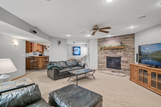 living area featuring a ceiling fan, a stone fireplace, recessed lighting, light carpet, and indoor bar