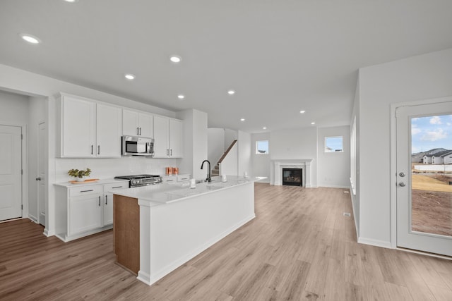 1520 Philipp Way, Shakopee, MN 55379 - kitchen with stainless steel microwave, range, healthy amount of natural light, white cabinets, and recessed lighting